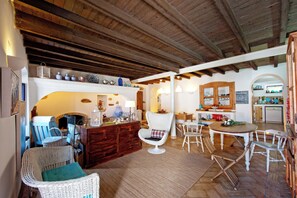 Un interior acogedor con chimenea, muebles de mimbre y una zona de cocina.