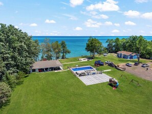 Ein Wohnhaus mit Schwimmbad, überdachter Terrasse und Seeblick.