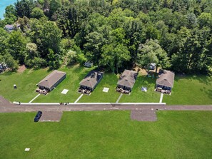 An aerial view of a residential area with four houses, each with a separate driveway and a small front yard.
