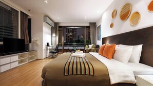 Una habitación de hotel moderna con una cama grande, televisión, escritorio y vistas a la ciudad.