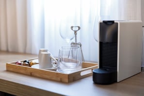 A coffee maker, a tray with a mug and glasses, and a wine opener on a wooden table. - Stay Boutique Ibirapuera (São Paulo)
