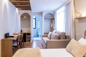 A hotel room with a bed, a desk, a chair, a sofa, and a view of the bathroom. - Stay Boutique Ibirapuera (São Paulo)