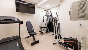 A gym with a treadmill, weight bench, and various exercise machines. - Stay Boutique Ibirapuera (São Paulo)