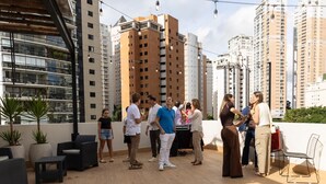 A rooftop terrace with outdoor seating and a view of high-rise buildings. - Stay Boutique Ibirapuera (São Paulo)