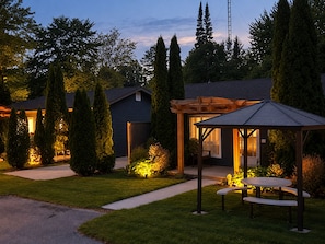 A residential property with a covered patio, a small garden, and a pathway leading to the entrance. - The Mermaid (Wasaga Beach)