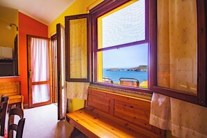 A room with a wooden bench, a view of the sea, and a door leading to another room. - Comfortable House with Large Terrace Sea View - Pistis - Green Coast-Arbus (Sardegna)