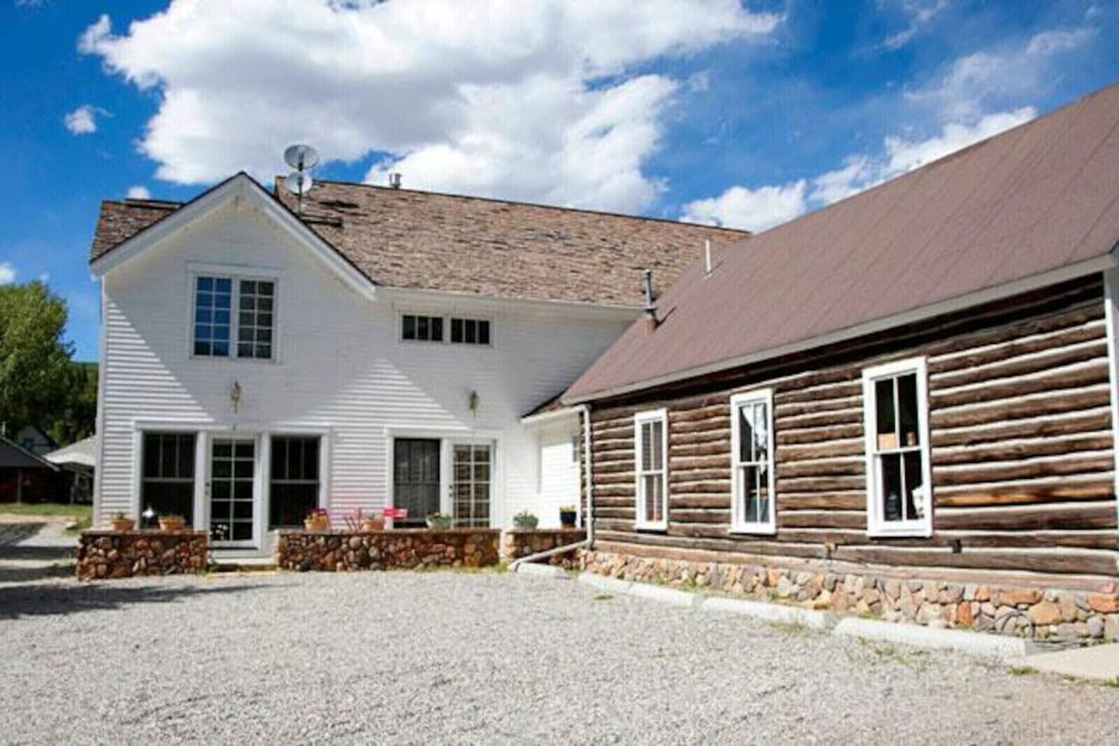Ein zweistöckiges Gebäude mit Steinbasis und Holzfassade.