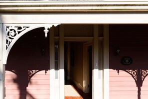 Entrada de un edificio con un arco decorativo, una puerta y un letrero que dice 'Alice's Cottage'.