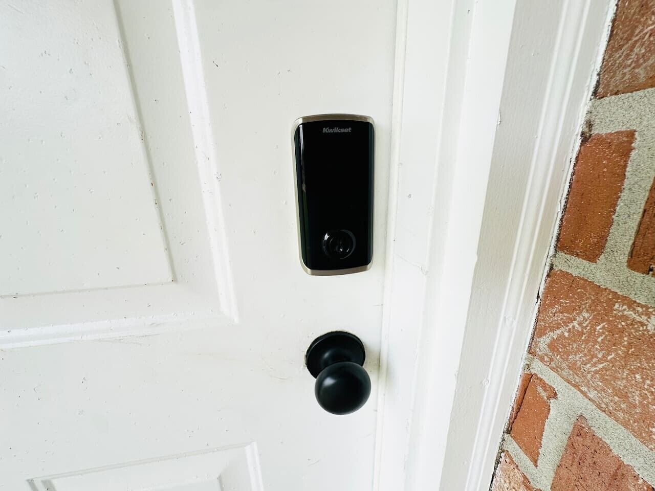 En vit dörr med ett Kwikset-lås och ett runt dörrhandtag.