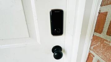 En vit dörr med ett Kwikset-lås och ett runt dörrhandtag.