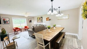 A spacious dining area with a large wooden table, multiple chairs, a sofa, and a ceiling fan. - Beautiful Eastgate 12B (Hammond)
