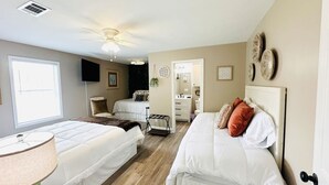 A bedroom with two beds, a ceiling fan, a window, and a door. - Beautiful Eastgate 12B (Hammond)