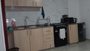 Una cocina equipada con fregadero, estufa, microondas y refrigerador.