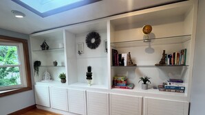 Una habitación con una estantería empotrada, un globo terráqueo y un ventanal con vistas a zonas verdes.