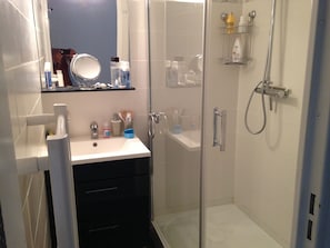 A modern bathroom with a glass shower enclosure, a vanity with a mirror, and a sink. - Rent beautiful duplex near Le Lavandou only from 11 to 18 /07 and after 22 08 (le lavandou)