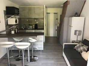 A modern kitchen with a microwave, coffee maker, and a dining area with bar stools. - Rent beautiful duplex near Le Lavandou only from 11 to 18 /07 and after 22 08 (le lavandou)