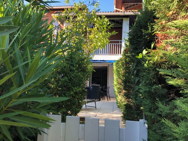 A building with a covered outdoor seating area, surrounded by dense greenery. - Rent beautiful duplex near Le Lavandou only from 11 to 18 /07 and after 22 08 (le lavandou)