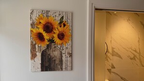 Eine Wand mit einem Sonnenblumenbild und ein Badezimmer mit Marmorfliesen.
