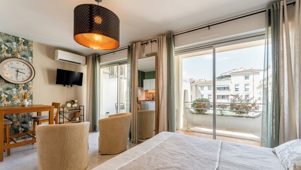 Ein Hotelzimmer mit Bett, Fernseher, Esstisch und einem Balkon mit Blick.