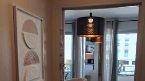 Ein Hotelzimmer mit Essbereich, einer modernen Pendelleuchte und einem gerahmten Kunstwerk an der Wand.