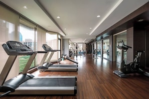 A modern gym with treadmills, exercise bikes, and weight machines. - KingBed|BTS&Park»5min|ParkView|Gym|Washer|FastWiFi - Apartment (Khlong Toei)