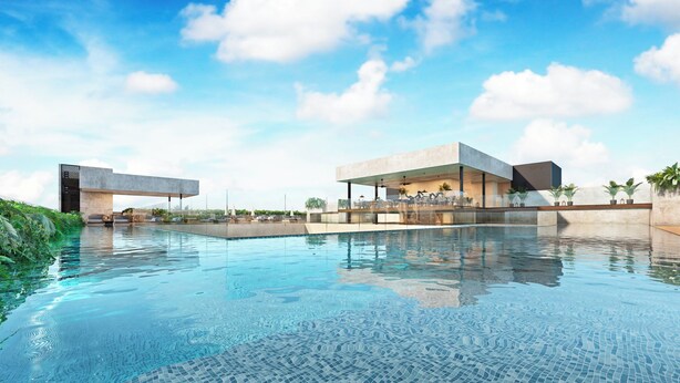 Un hôtel moderne doté d’une piscine, d’un espace extérieur aménagé et offrant une vue sur un ciel d’un bleu éclatant.