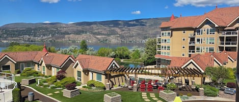A residential area with a pool, outdoor seating, and a view of mountains.