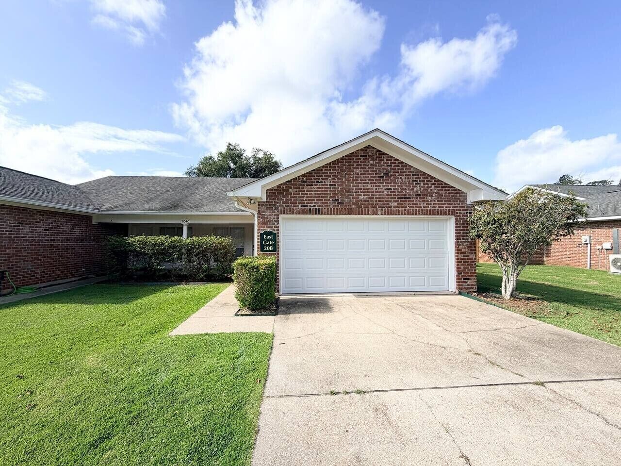 A residential house with a garage, a well-maintained lawn, and a clear sky.