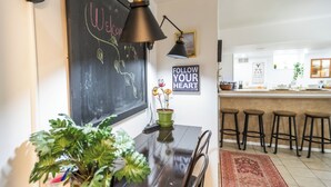 A kitchen with a chalkboard, bar stools, and a red rug. - 2 Connected Private Suites| 0.4mi OWU |Free Parking|Quiet Street|Patio|W/D (Delaware)