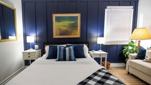 A neatly made bed with pillows, a bedside table with a lamp, a nightstand with a lamp, a wall-mounted painting, and a window with blinds. - 2 Connected Private Suites| 0.4mi OWU |Free Parking|Quiet Street|Patio|W/D (Delaware)