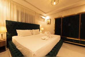 A hotel room with a large bed, a wardrobe, a nightstand, and a lamp. - Charming, family-friendly 2-bedroom apartment with AC in Marrakesh Targa (Marrakesh)