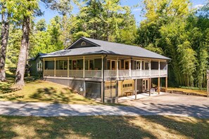 A two-story lodge with a balcony, a covered porch, and a fenced yard.