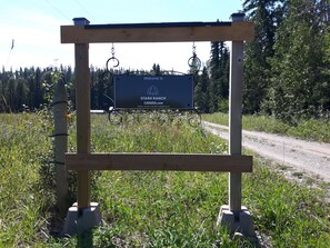 A wooden signboard with a welcome message for Stark Ranch, indicating it is a cabin rental and RV campground.
