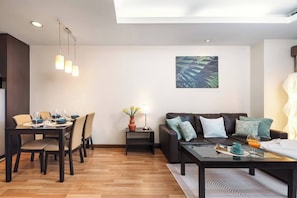 Ein modernes Wohnzimmer mit Essbereich, einer Sofagarnitur und einem Bild an der Wand.