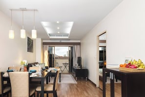 Ein modernes Wohnzimmer mit Essbereich, Fernseher und Balkon mit Stadtblick.