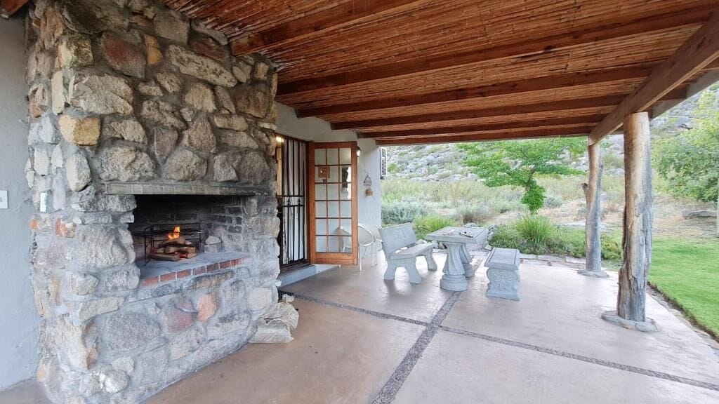 A stone fireplace, outdoor seating, and a covered patio area.