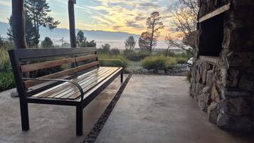 Un banco con vistas a montañas y un atardecer.