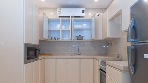 Uma cozinha equipada com micro-ondas, fogão, pia e armários.