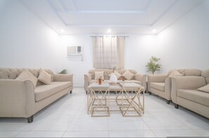 Ein modernes Wohnzimmer mit zwei Sofas, einem Couchtisch und einer Deckenleuchte.