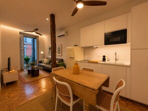 Una cocina compacta con comedor, ventilador de techo y microondas integrado.