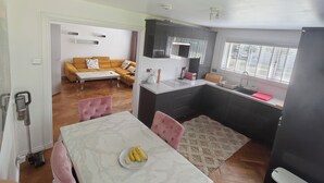 En kompakt bolig med spiseplads, køkken og sofa i stuen.