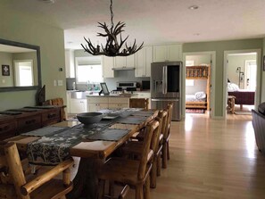 Una cocina amplia con comedor, muebles de madera y una araña.