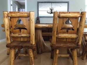A dining area with a rustic wooden table and chairs.