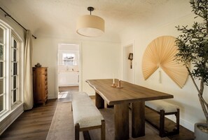 Un comedor con una mesa de madera, bancos y un ventilador de techo.