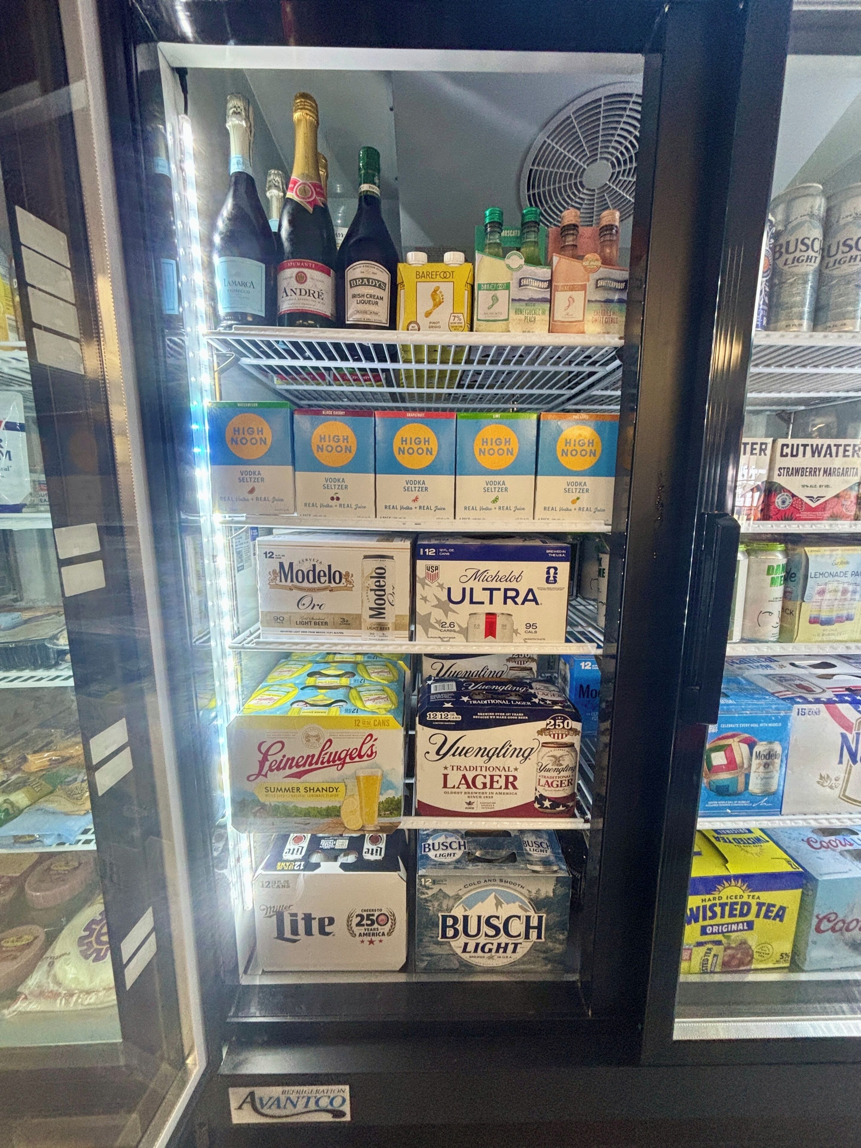 A vending machine stocked with various alcoholic beverages including bottles, cans, and boxes.