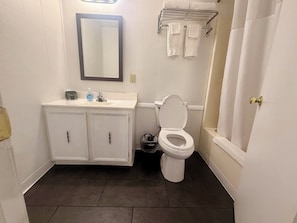 A bathroom with a white sink, mirror, toilet, and a towel rack.
