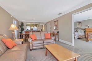 A living room with a sofa, a coffee table, and a dining area with a table and chairs. - Expanded Saddlebrook 2bed/2bath Condo. Sleeps 8 (Zephyrhills)