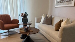 Ein modernes Wohnzimmer mit einer Couch, einem Sessel, einem Couchtisch und einer Wand-Klimaanlage.