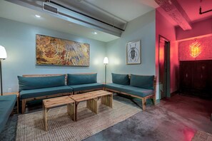 A modern living room with a sectional sofa, a coffee table, and artwork on the walls. - 3 Bedroom Apartment, French Quarter, Central Location, Pool, Walkable (New Orleans)