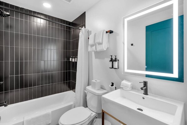 A modern bathroom with a bathtub, toilet, and sink.